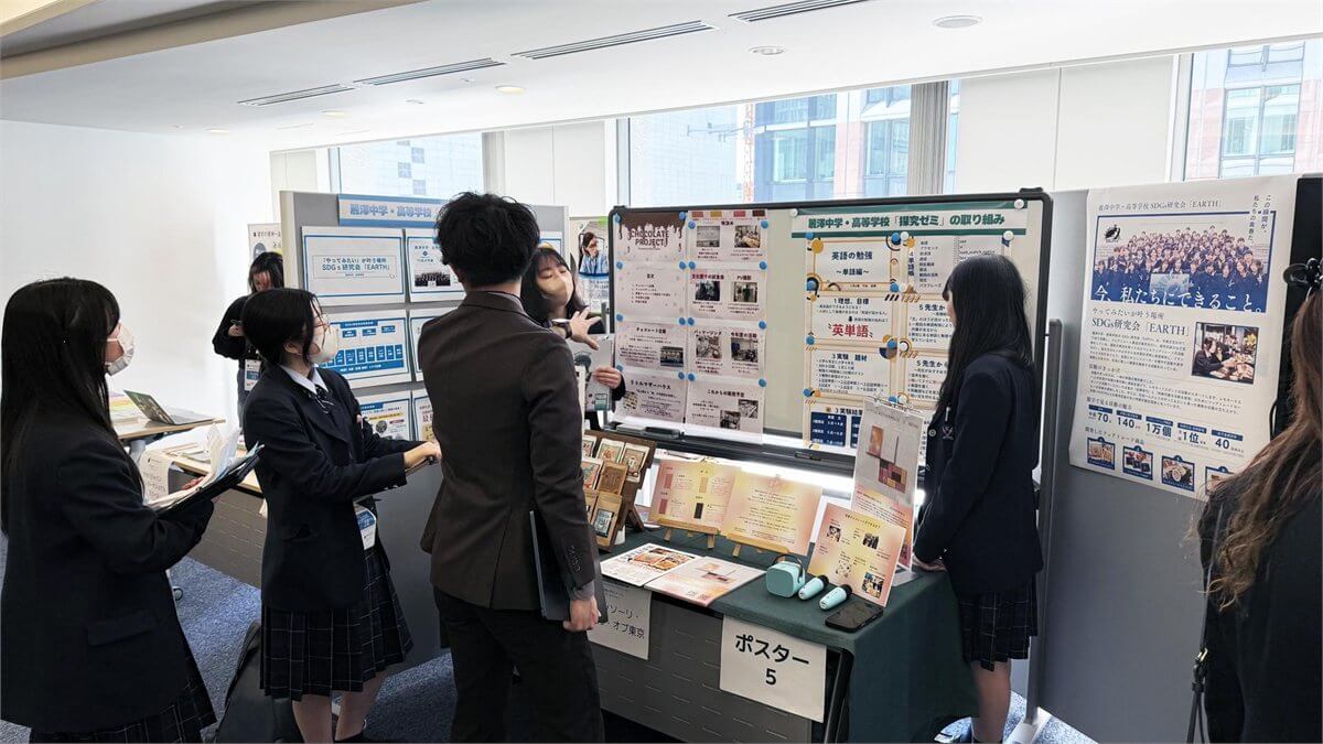 探究ポスターの前で来場者に説明する生徒